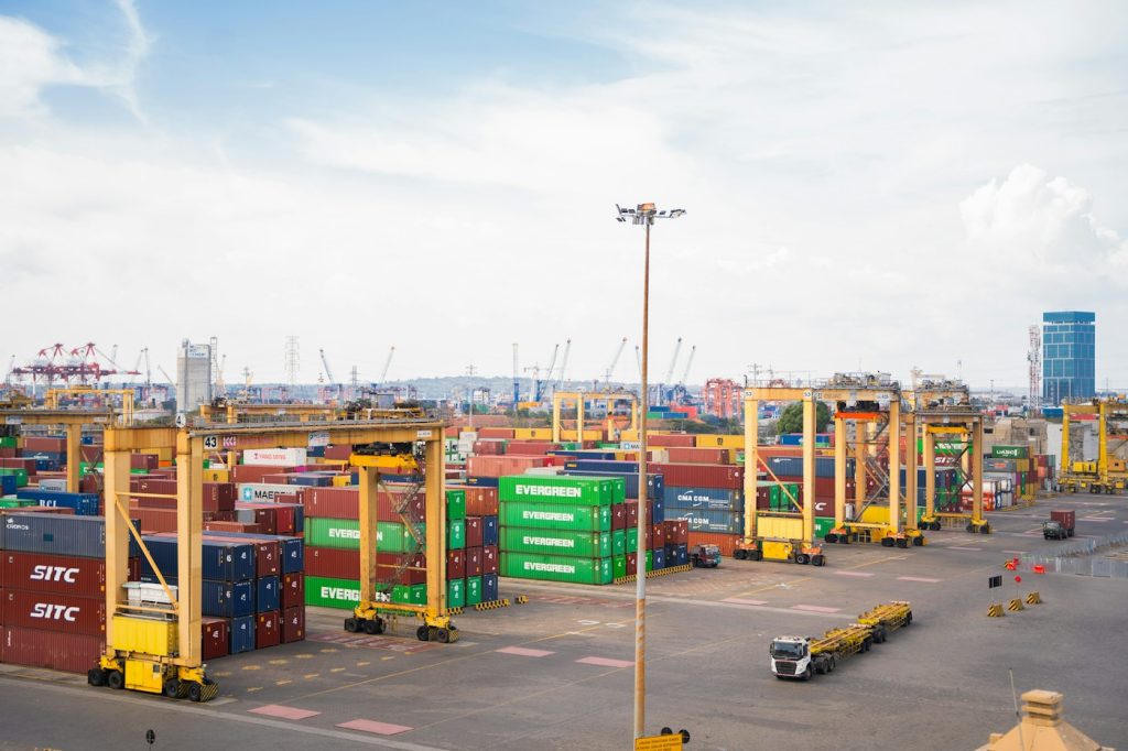 Terminal portuale con container impilati e gru gialle per la movimentazione delle merci
