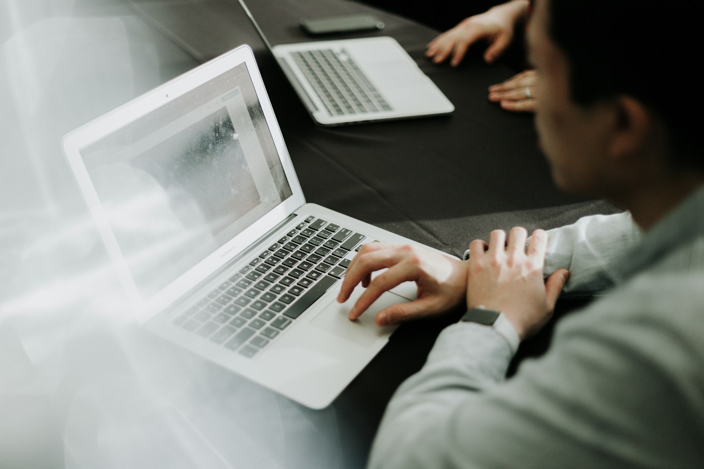 Persona seduta davanti a un computer portatile durante un’attività di lavoro